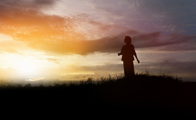 Fototapeta na wymiar silhouette of woman walking on the mountain at sunset