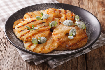 Fresh pineapple fried with mint close up on a plate. horizontal