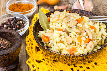 Pilaf with meat, rice and zira in a wooden bowl