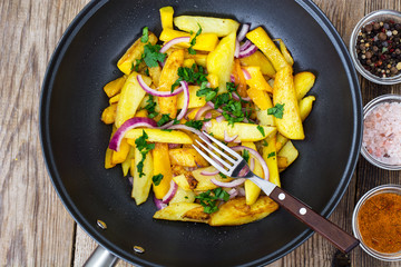Fried potatoes with pumpkin and red onion