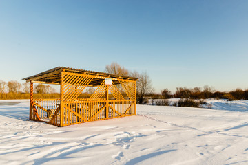 a gazebo in the snow in a field