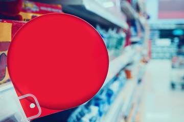 red discount sign display on supermarket shelves