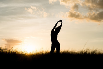 Women exercising in Meadow at sunset