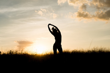 Women exercising in Meadow at sunset