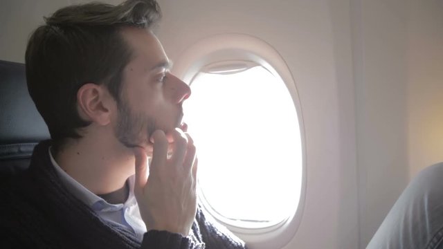 Ragazzo nervoso per il viaggio in aereo si tocca la barba