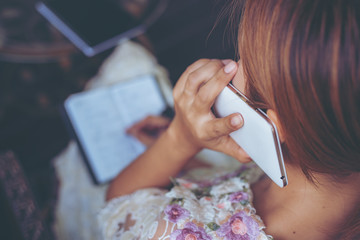 home office desk background,hand holding pencil and writing note on wood table,Checklist Notice Remember Planning Concept