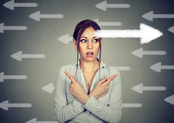 woman has second thought perplexed pointing fingers in different direction