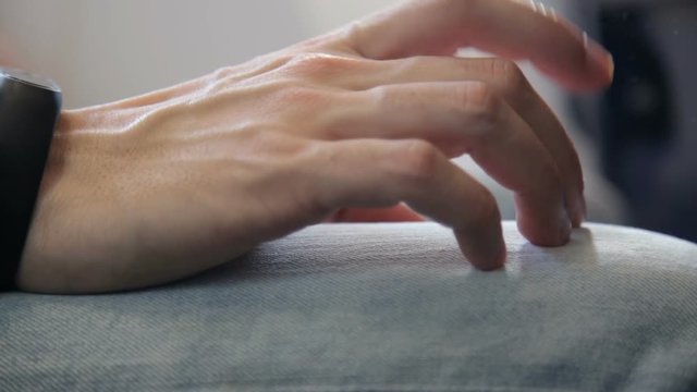 Persona stressata e impaurita si tocca le gambe nervosamente durante il volo dentro un aereo