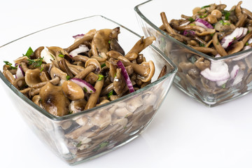 Marinated mushrooms and onions in a glass salad bowl