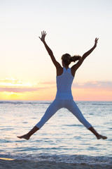 Obraz premium femme heureuse qui saute sur la plage en été
