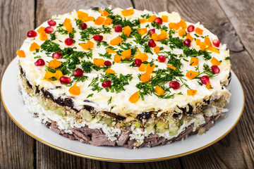 Layered salad with meat and pomegranate seeds