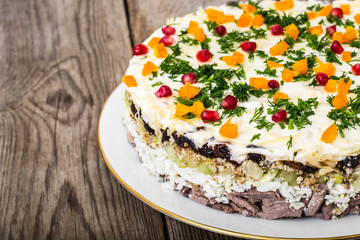Layered salad with meat and pomegranate seeds