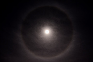 Full moon in a cloudy sky with halo