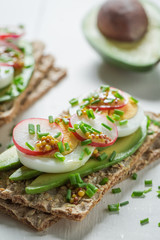 Fresh crispy bread with avocado, radish and eggs