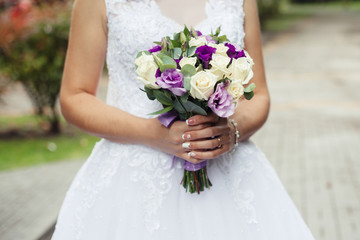 Wedding. The bride in a dress standing in a green garden and hol