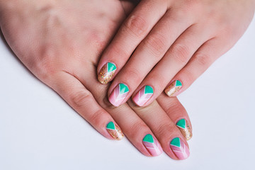Nail art with bright gold, pink and green chevron pattern