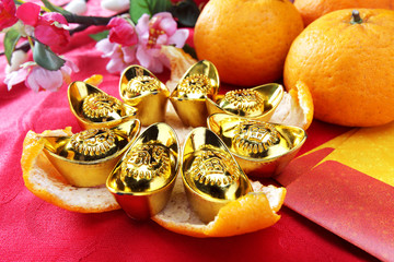 Happy Chinese New Year / golden ingots on mandarin orange peel