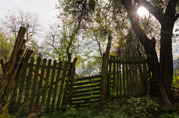 Old wooden gate and fence in a shade and a few sunrays, Homolje mountains, east Serbia