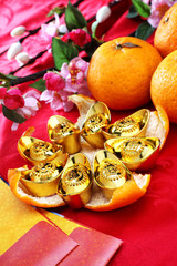 Happy Chinese New Year / golden ingots on mandarin orange peel