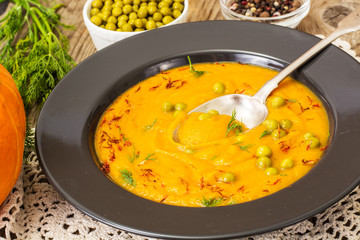 Vegetarian food: vegetable soup with green peas in black plate