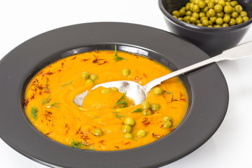Vegetarian food: vegetable soup with green peas in black plate