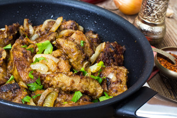 Fried beef liver with onions, curry and spices