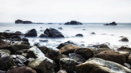 Fototapeta na wymiar Long exposure of a rocky coast of the Ocean