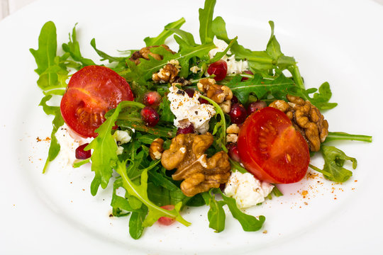Vegetarian salad with arugula, cherry tomatoes and pomegranate