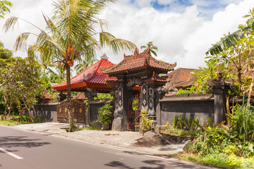 Fototapeta premium House with figured gate and tiled roof in Ubud, Indonesia. Traditional asian architecture.