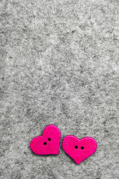 Wooden pink hearts on gray felt background, copy space