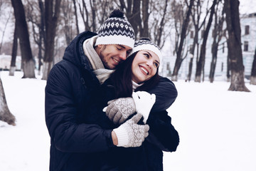 Young couple hugging and smiling in the park.