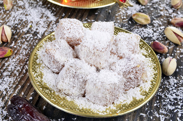 Turkish delight with coconut and tea on wooden table