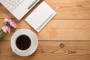   Office table with cup of coffee and flowers 