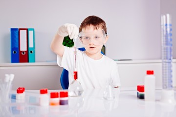 Boy mixing colored liquids in test tubes