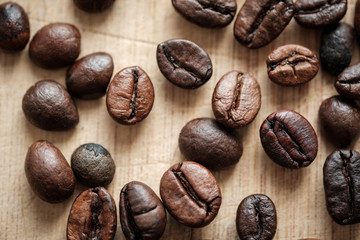 Detail view of coffee beans on wooden background. Macro shoot.