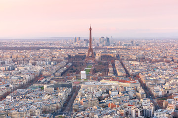 Aerial view of Paris skyline with Eiffel Tower, Les Invalides and business district of Defense at pink sunset, as seen from Montparnasse Tower, Paris, France