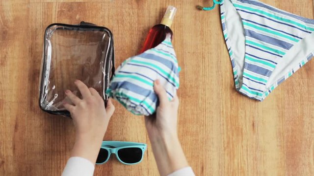 hands packing beach accessories to bag