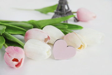 spring and holiday card/eiffel tower and pink and white tulips on white background with selective focus