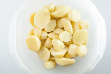 Sliced, peeled raw potatoes in a bowl