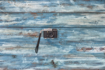 Photo camera on a blue old vintage wooden blue background. Photographed in retro style