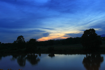Fototapeta na wymiar Sunset sky colorful silhouette river time twilight woodland 