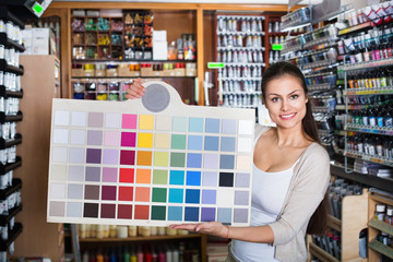 Portrait of young woman holding color sample palette