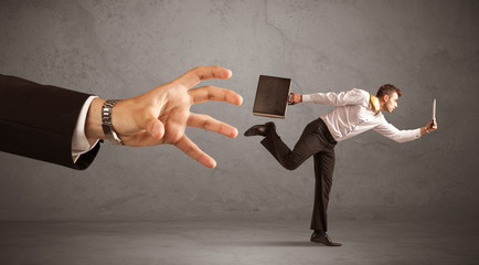 Businessman running from hand