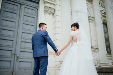 Fototapeta premium Wedding. Wedding day. Wedding couple. Beautiful couple, bride and groom look at each other and smiling against a white castle