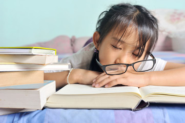 asian child sleeping while reading in the bed, selective focus