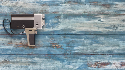 Video camera on a blue old vintage blue background. Photographed in retro style