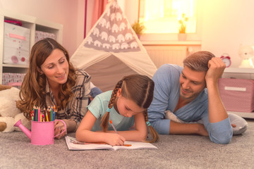 kind zeigt eltern ihr talent beim malen und schreiben