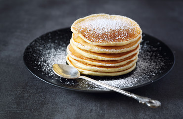 Portion of pancakes with icing sugar