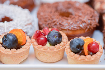 Mini tarts with vanilla cream, blueberries and pomegranate