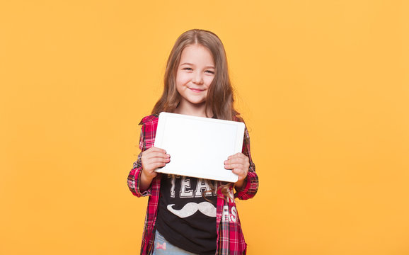 Smiling little girl holding up a blank tablet computer